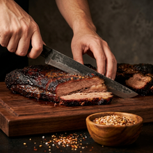 Person slicing meat with the Mamba long hand forged brisket slicing knife