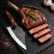 Mastodon hand forged clip point cleaver with steak, close view of the blade